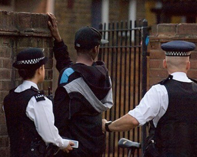 two police officers interacting with a person near a fence depicting a moment of law enforcement in action with a focus on community safety and engagement